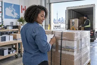 Warehouse specialist inspecting a secured pallet shipment at a clean dispatch dock