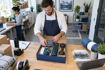 Commerçant disposant les différents produits d’un coffret-cadeau dans un emballage ajusté