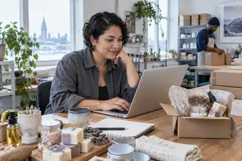 Retailer reviewing a customer order on a laptop beside the corresponding products