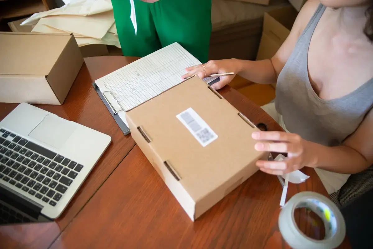 Small-business owner packing subscription orders at a worktable