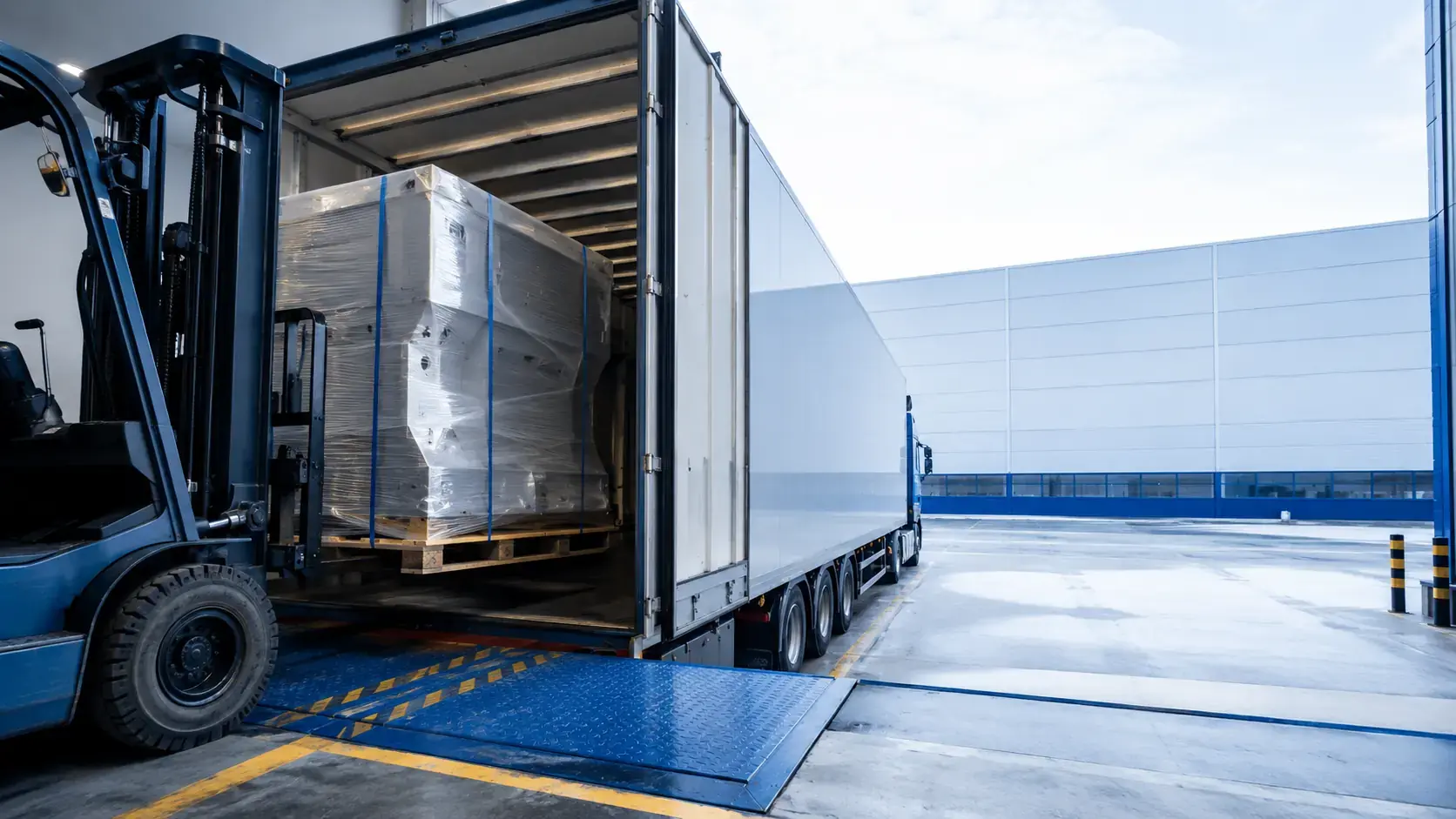 A warehouse team loads secured freight for dispatch